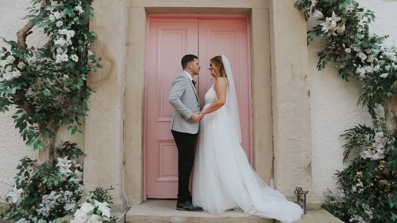 Sami and Dareen together by a pink doorway framed with flowers